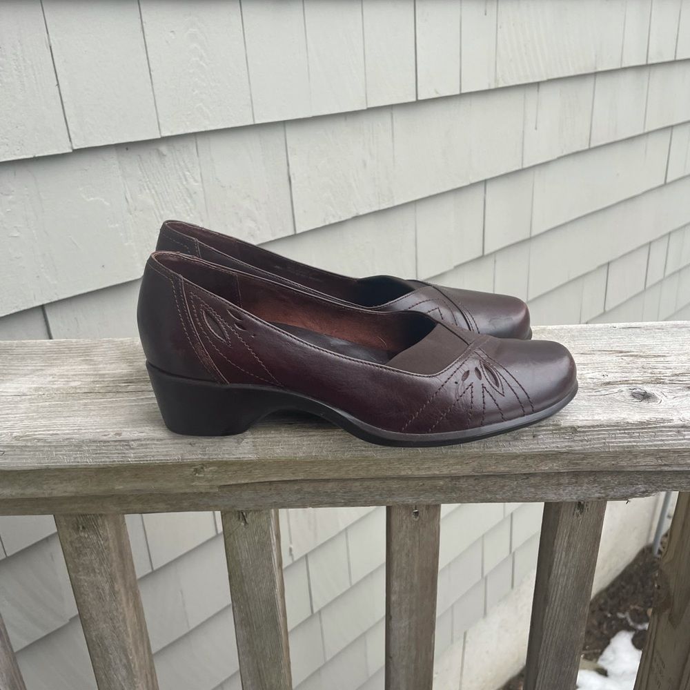 Loafer low heeled closed toed shoes with almost floral looking details.